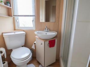 a small bathroom with a toilet and a sink at Winchester - 244 in Rhyl +16 photos