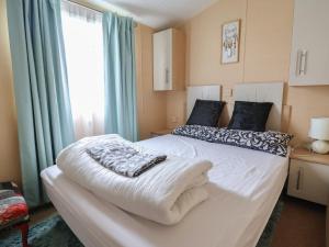 a bedroom with a large white bed with a window at Winchester - 244 in Rhyl