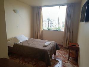 a bedroom with a bed and a large window at Kibo Hotel in Ayacucho