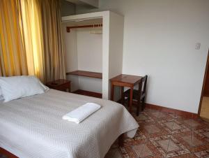 a bedroom with a bed with two towels on it at Kibo Hotel in Ayacucho