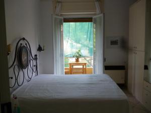 Un dormitorio con una cama grande y una ventana en Bilocale Imperatrice, en San Remo