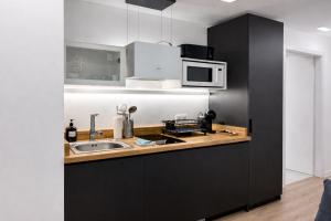 a kitchen with a sink and a microwave at Nova MSuites Valencia in Valencia