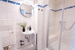 a white bathroom with a sink and a shower at BetterBeds Wilhelm City in Brandenburg an der Havel