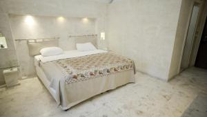 a bedroom with a large bed with white sheets and pillows at Kasr-i Nehroz Hotel in Midyat