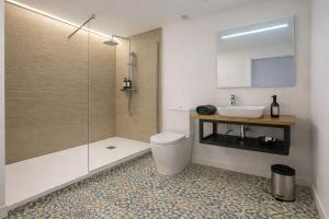 a bathroom with a shower and a toilet and a sink at Nova MSuites Valencia in Valencia