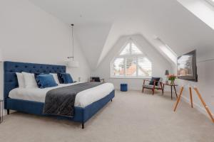 a bedroom with a blue bed and a window at The Laurels by Grandeur Property in Poole