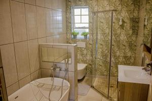 a bathroom with a shower and a toilet and a sink at Kruger's Rest Guest House in Hazyview +38 photos