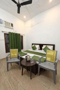 a bedroom with a bed and two chairs and a table at Hotel Vijay Palace- Near Ram Mandir Ayodhya in Ayodhya