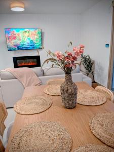 a dining room table with a vase of flowers on it at Casa rural Doble-R in Ronda +9 photos