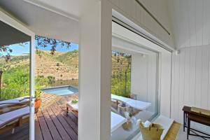 a room with a balcony with a view of a pool at Casa do Rio - Douro Wine Hotel by Vallado in Vila Nova de Foz Coa