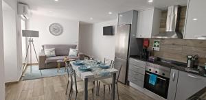a kitchen and living room with a table and a couch at Casa da Avó Biza in São Roque do Pico