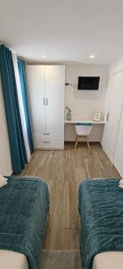 a room with two beds and a tv in it at Casa da Avó Biza in São Roque do Pico