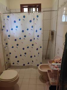 a bathroom with a toilet and a shower curtain at Gästehaus Samaipata in Samaipata