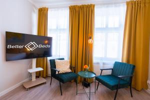 a room with chairs and a flat screen tv at BetterBeds Wilhelm City in Brandenburg an der Havel