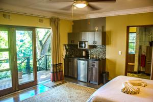 a room with a kitchen with a bed in it at Kruger's Rest Guest House in Hazyview