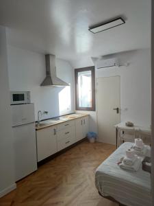 a kitchen with white cabinets and a sink and a table at Dulcinea in Seville