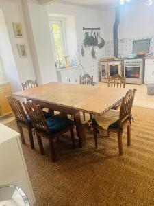 a wooden table in a kitchen with chairs around it at B&B by the River Beach in Mega Fundeira