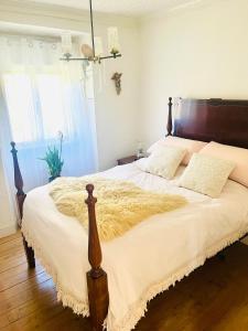 a bedroom with a large bed with a wooden headboard at B&B by the River Beach in Mega Fundeira