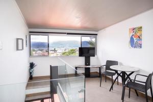 a living room with a table and chairs and a window at Casa Irazú in Cartago