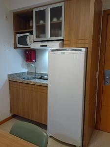 a small kitchen with a refrigerator and a microwave at Flat Particular Marizienne Hotel Saint Moritz 86 in Brasília