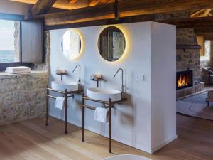 two sinks in a bathroom with a fireplace at Le Torri di Credazzo in Farra di Soligo +36 photos