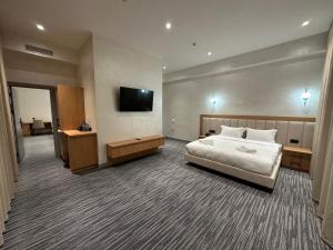 a hotel room with a bed and a flat screen tv at Velnora Hotel in Tashkent