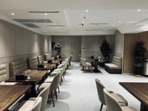 a restaurant with wooden tables and chairs and tablesktop at Velnora Hotel in Tashkent
