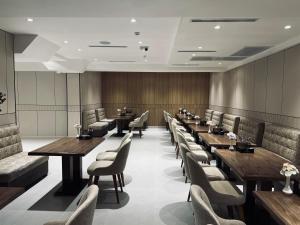 a dining room with wooden tables and chairs at Velnora Hotel in Tashkent