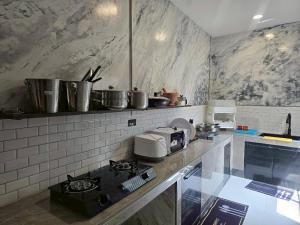 a kitchen with a stove and some pots and pans at 65 Poolvilla in Ban Tao Than