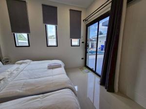 a bedroom with two beds and a large window at 65 Poolvilla in Ban Tao Than +16 photos