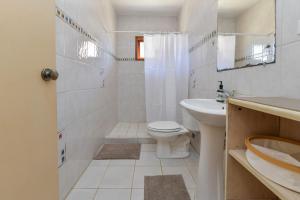 a white bathroom with a toilet and a sink at Arantxa Residence in Noord +6 photos