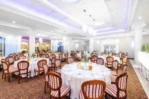 a banquet room with white tables and chairs at Hotel Lord - Warsaw Airport in Warsaw