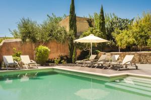 a swimming pool with lounge chairs and an umbrella at Estrellas Luxury Villas in Svoronata