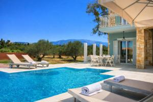 a villa with a swimming pool and a patio at Estrellas Luxury Villas in Svoronata