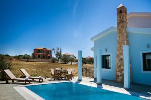 a villa with a swimming pool and a house at Estrellas Luxury Villas in Svoronata