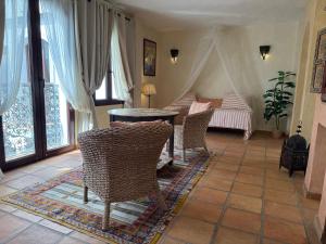 a living room with chairs and a table and a bed at Darcilla Guest House in Tarifa