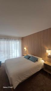a bedroom with a large white bed with two blue pillows at Residence Club Inn in Nice