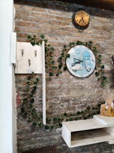 a wall with a clock and ivy on it at Pace con la natura in Casa Manara