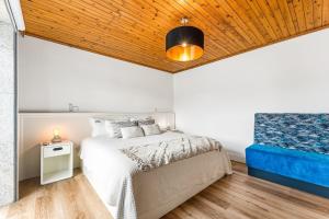 a bedroom with a bed and a wooden ceiling at GuestReady - Quinta da Devesa in Vila Nova de Gaia