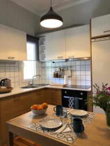 a kitchen with a table with a bowl of oranges on it at Lemonaki House Lefkada in Asprogerakata +31 photos