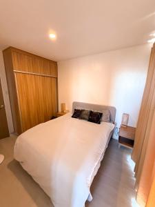 a bedroom with a large white bed with two pillows at Enzos Haven - Tagaytay in Tagaytay +22 photos