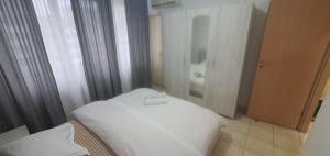 a white bed in a room with a bathroom at 5th Floor Oasis 2 Badroom Apartment in Bucharest