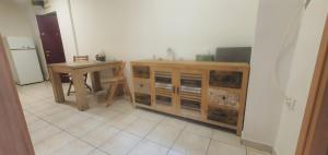 a kitchen with a table and a wooden cabinet at 5th Floor Oasis 2 Badroom Apartment in Bucharest