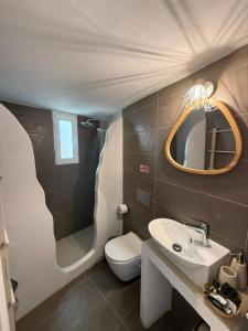 a bathroom with a toilet and a sink and a mirror at Akti Rooms And Studios in Livadi +136 photos