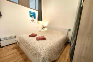 a bedroom with a bed with two towels on it at Spacious cocoon close to the beach in Ajaccio +6 photos