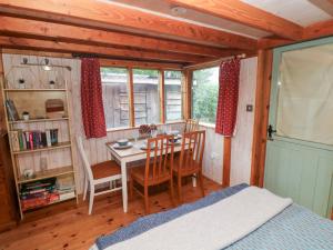 a bedroom with a table and chairs and a bed at Cosy Eco Cabin in Newport