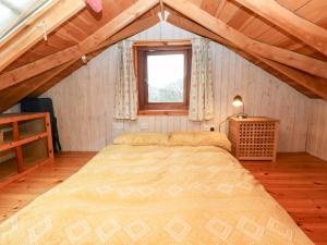 a bedroom with a large bed in a attic at Cosy Eco Cabin in Newport
