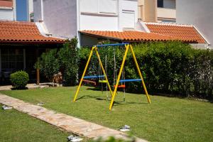 a swing set in the yard of a house at Sea Breeze Alexandroupolis in Alexandroupoli