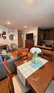 a living room with a vase of flowers on a table at ESTRELLA del GUADALQUIVIR in Arroyo Frio