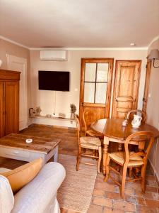 a living room with a wooden table and chairs at La Bastide des Dentelles in Roaix